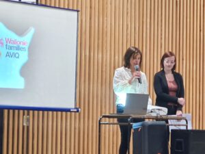 2 intervenantes en conférance devant un écran dont l'une tient un micro